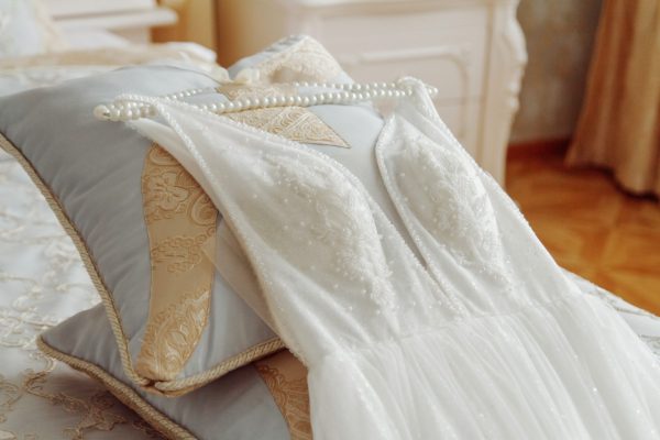 Wedding dress with hanger laying on the bed Wedding dress with hanger laying on the bed.